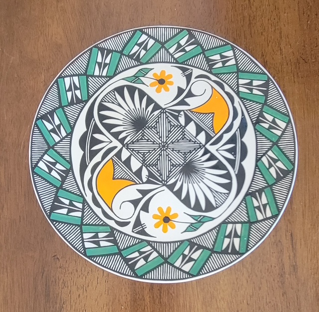 Green, orange and black Acoma plate with a four-direction center